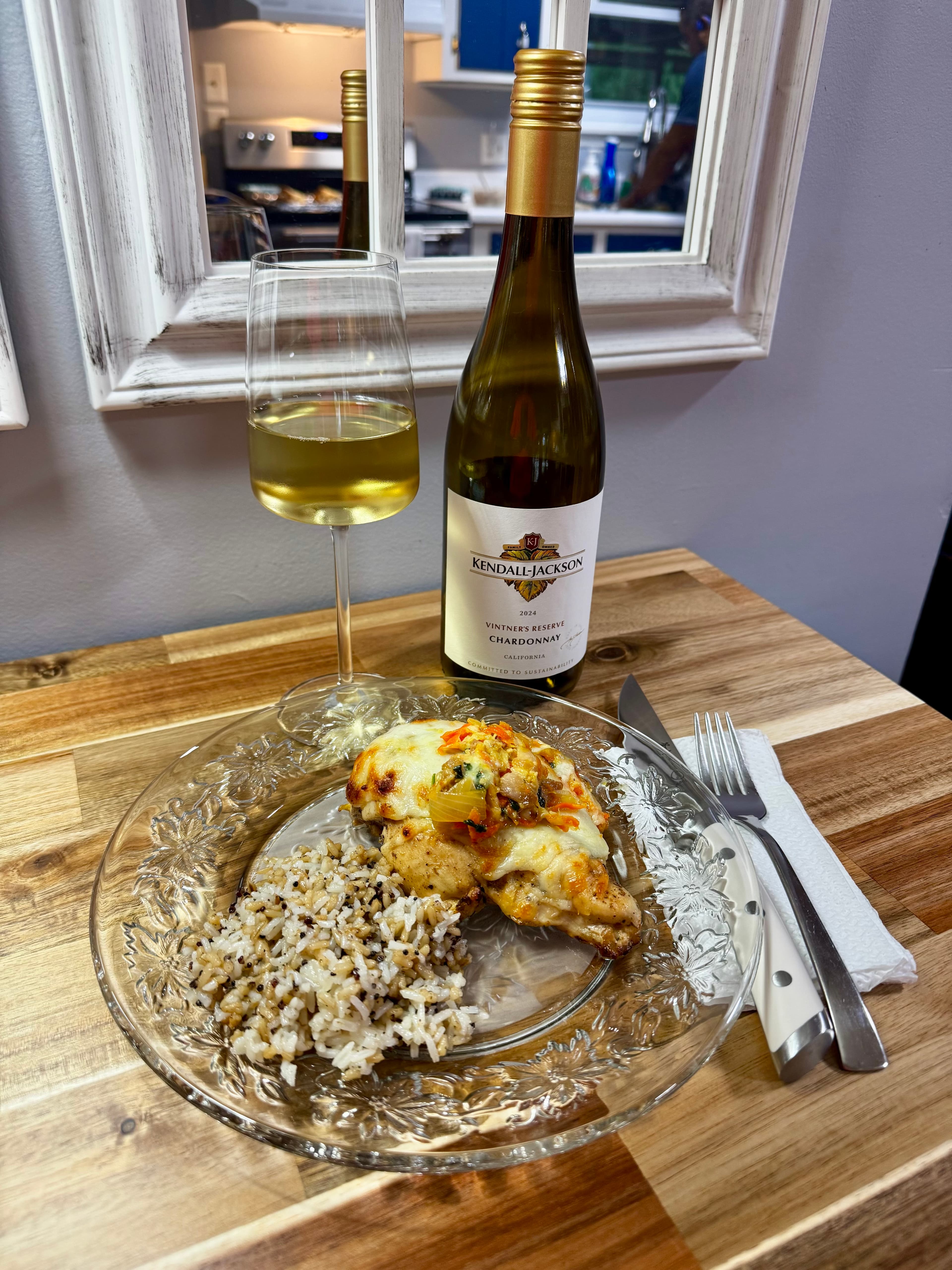 Stuffed chicken breast with coconut quinoa rice beside a glass and bottle of Kendall-Jackson Chardonnay