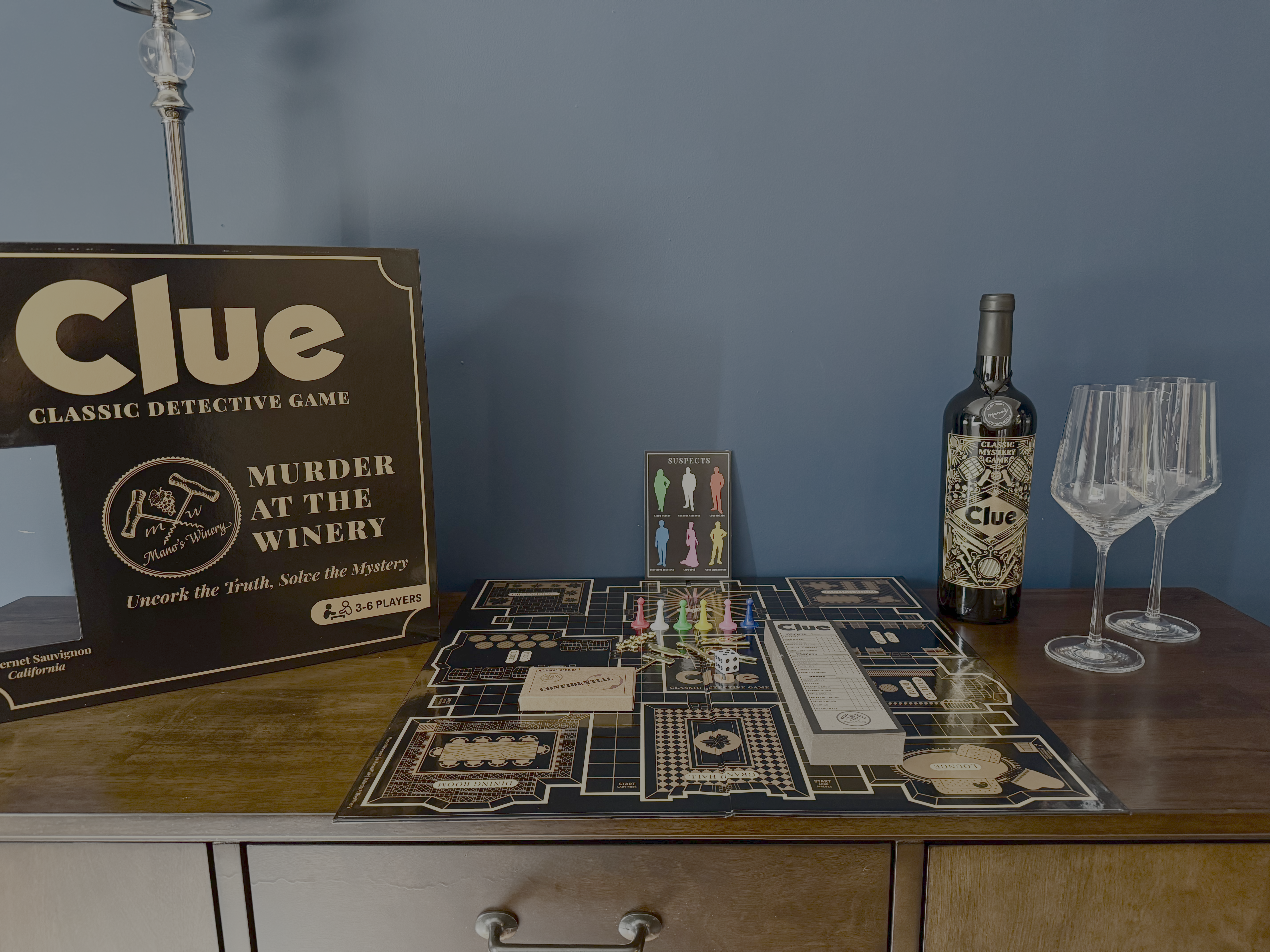 Wine Lovers edition of Clue beside a glass of red wine